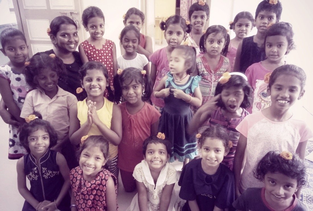 A group of children supported by KarmaCorps, gathered indoors